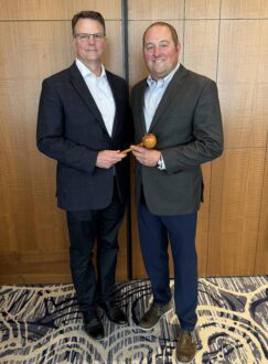 Steve Clement, from left, passes the gavel of the leadership of USApple's board of directors to Brett Baker. Baker became chair at USApple’s Aug. 14-16 Chicago Outlook conference.