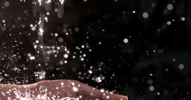 Black background with water falling into hands for washing.